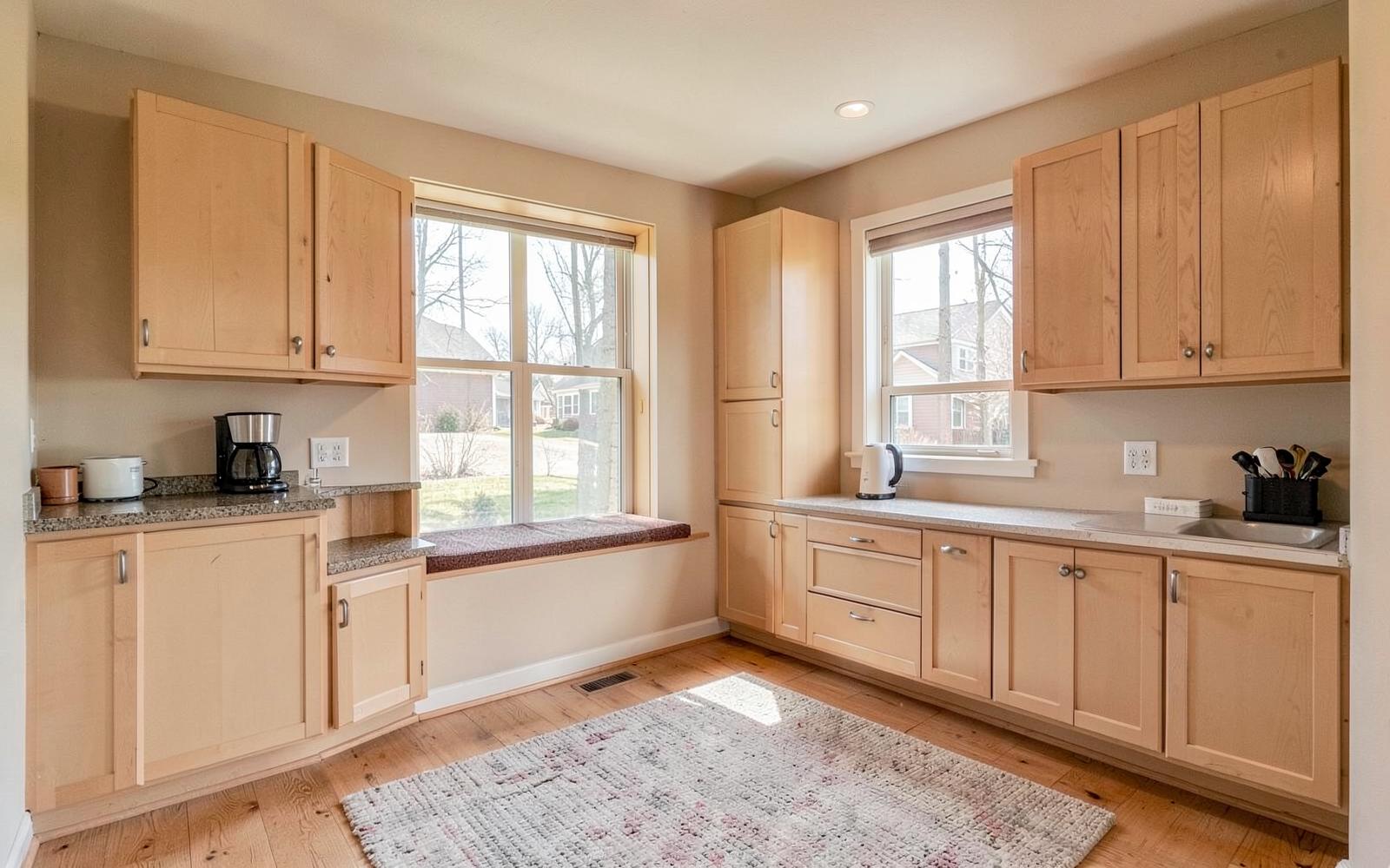 New in-law suite sitting room with kitchenette cabinets and window seat