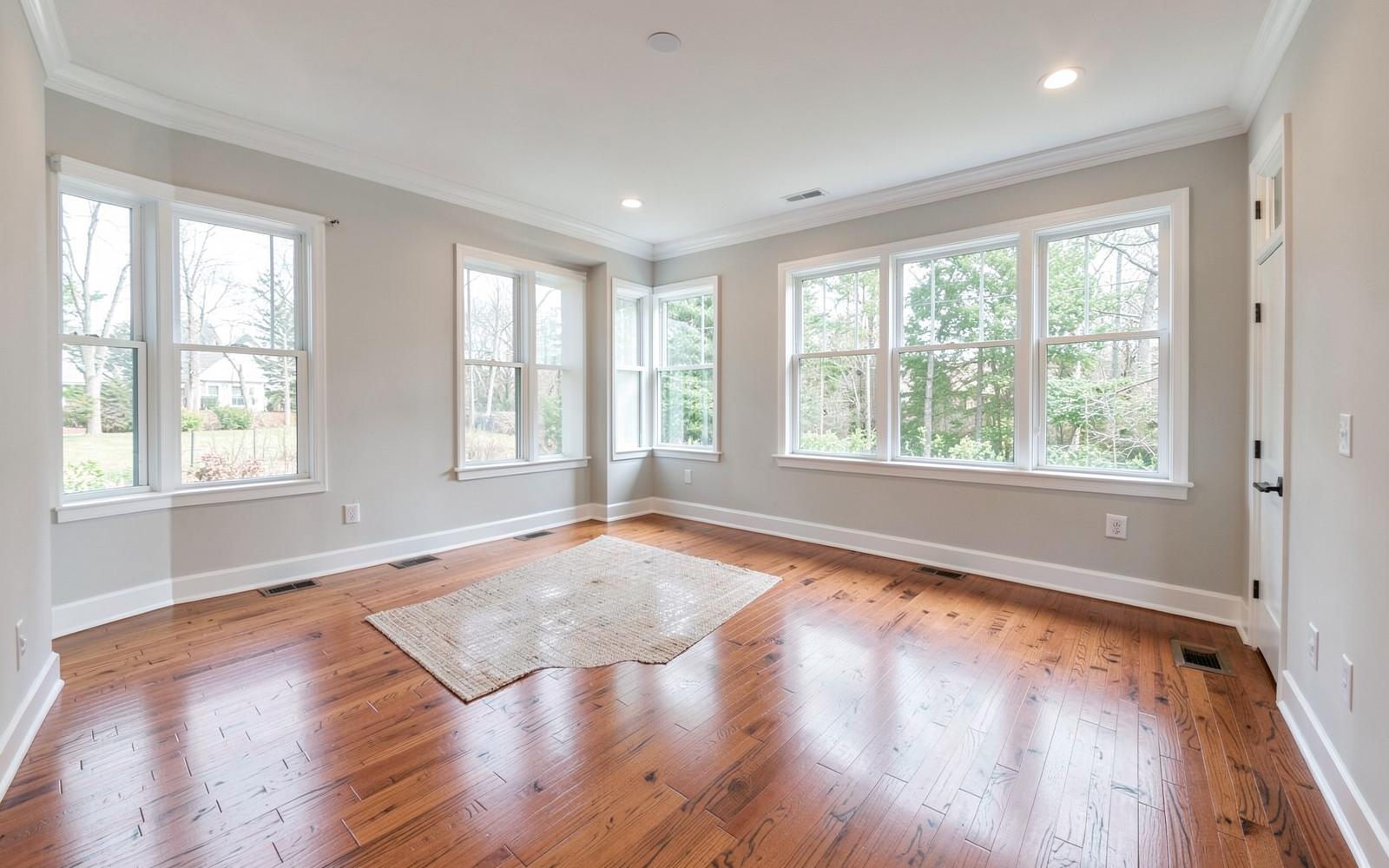 Finished interior of a family room addition with hardwood floors and recessed lighting