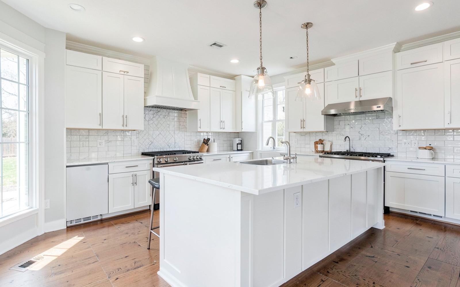 Expanded kitchen with quartz island and pendant lighting after a house extension