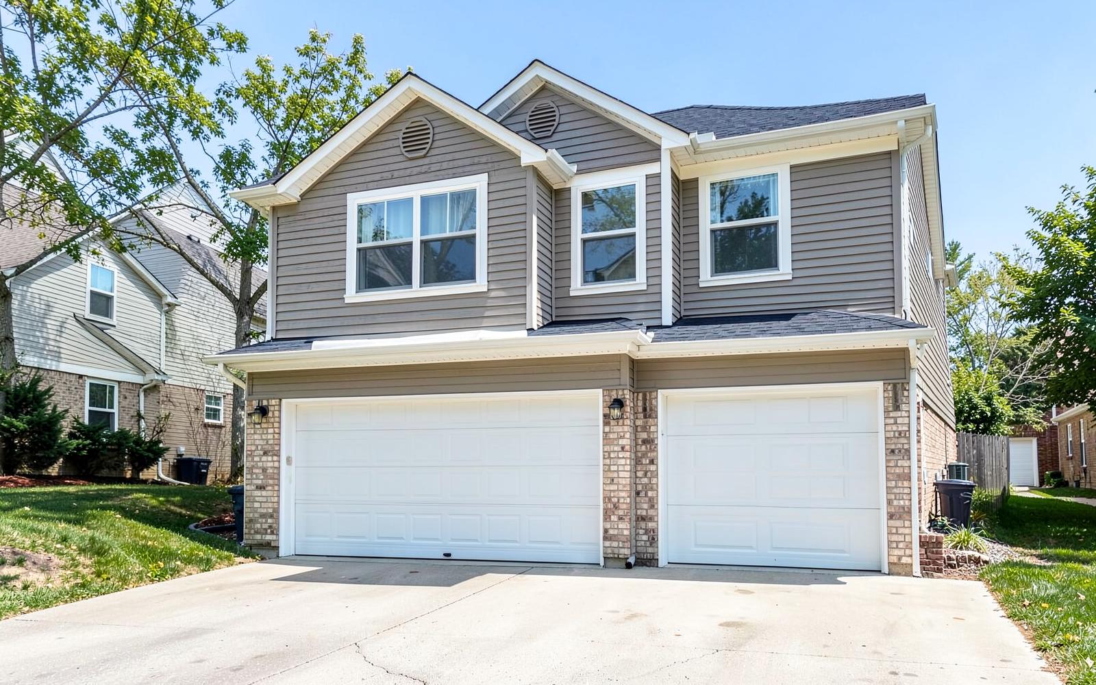 Completed room addition built above a two-car garage with matching siding