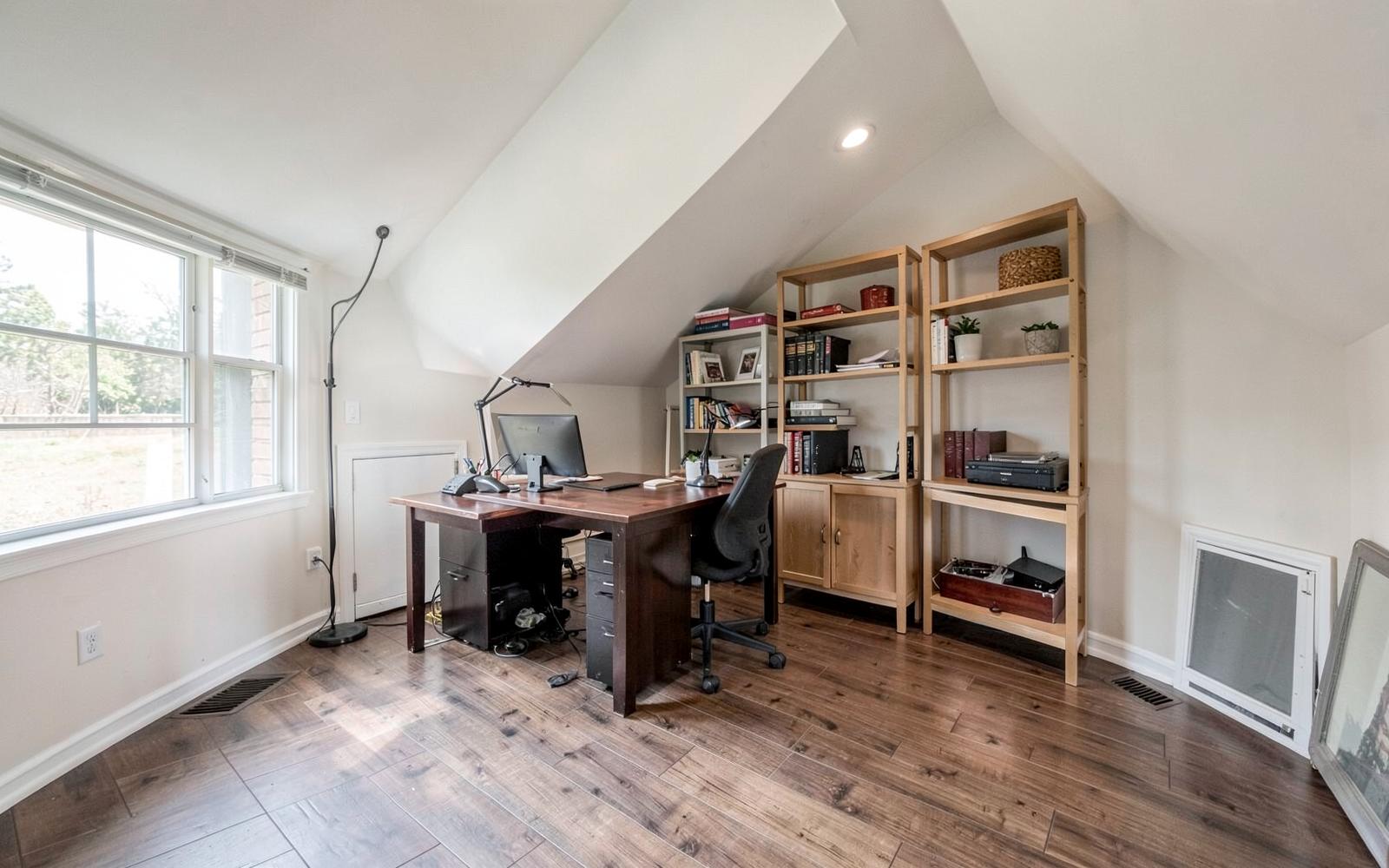 Finished bonus room over a garage used as a home office with sloped ceiling