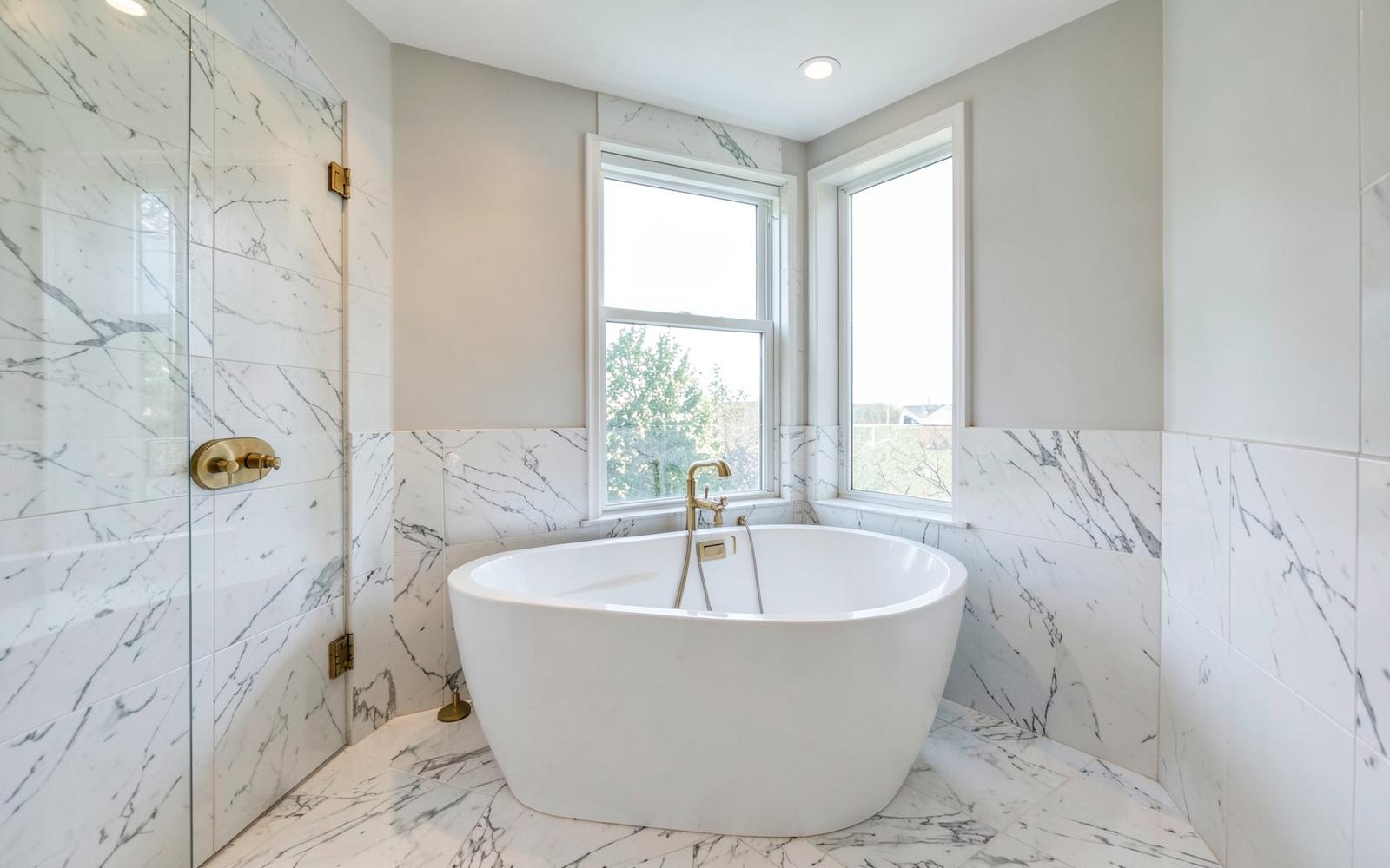 Luxury primary bathroom addition with freestanding tub and marble tile