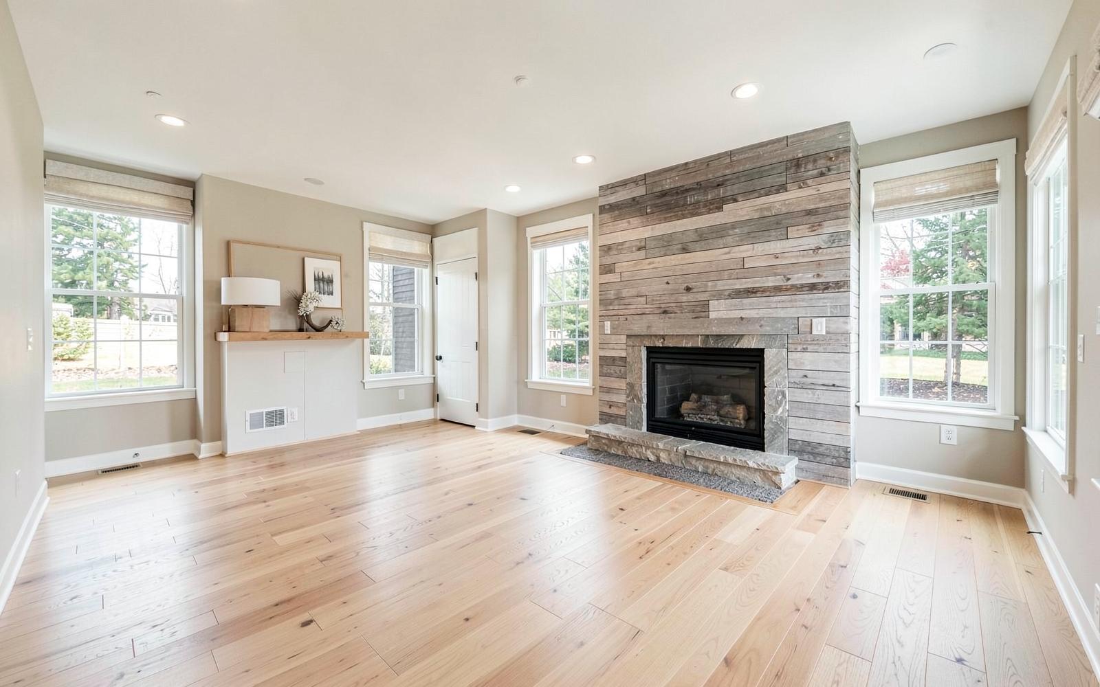 Open-concept living room addition with shiplap fireplace wall and oak floors
